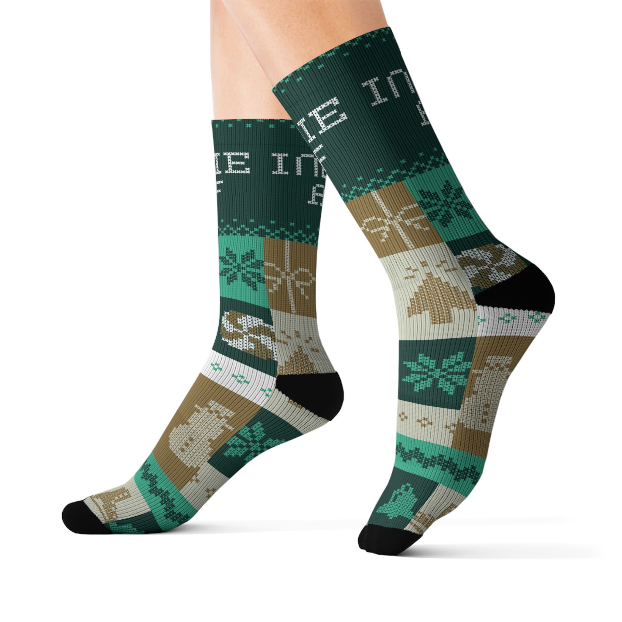 A person wears The "Cold Feet" Socks - Gold from Indie AF 2025 Holidays by Grown, featuring festive Christmas designs in green, brown, white, and black such as snowflakes, snowmen, and gifts.