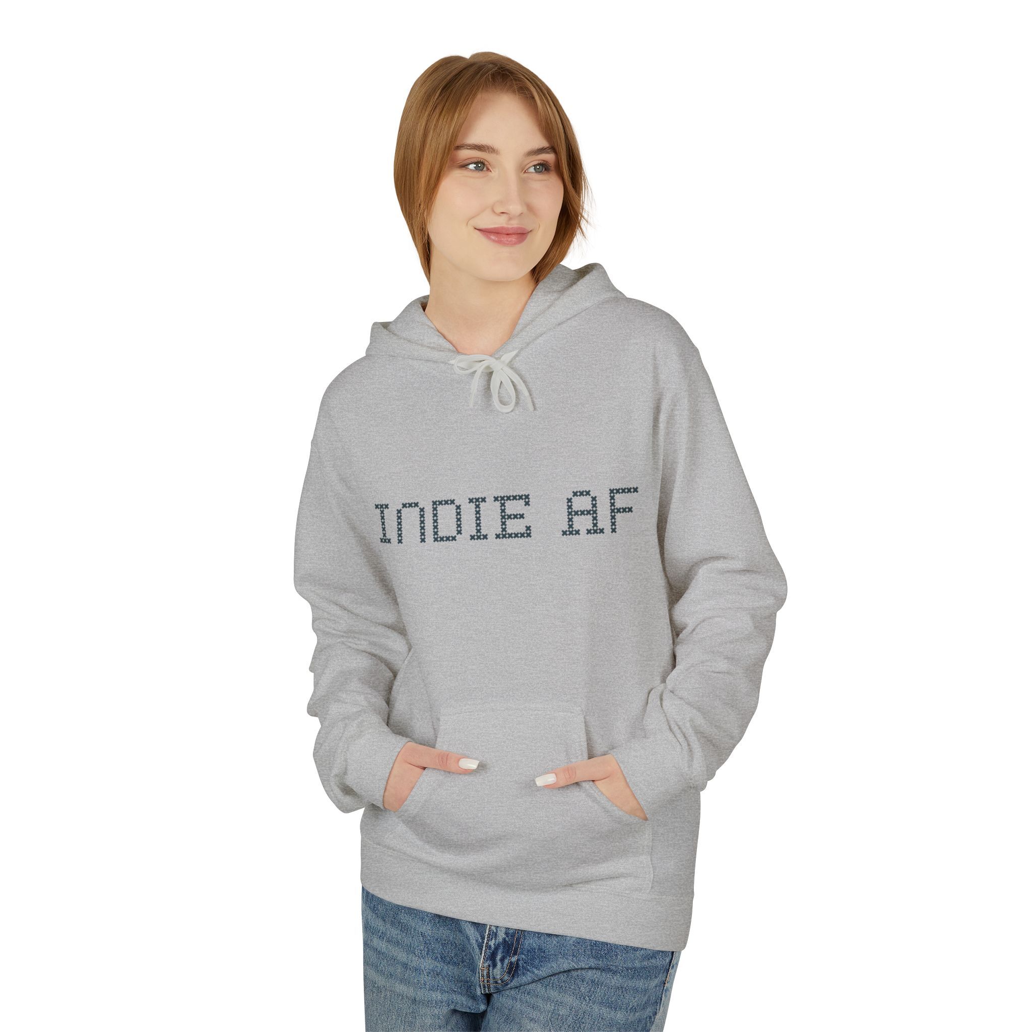 Someone wearing The "Uniform Rebellion" Hoodie | Indie AF 2025 Holidays by Grown in light gray stands confidently with hands in pockets against a plain white background.