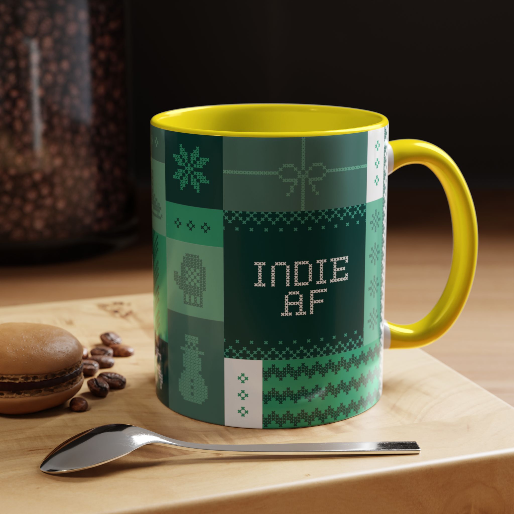 The "Mandatory Fun" Mug - Green | 11oz Indie AF 2025 Holidays by Grown features pixel art and sits on a tray with a spoon, macaron, and coffee beans—perfect for the holidays or any occasion needing some fun.