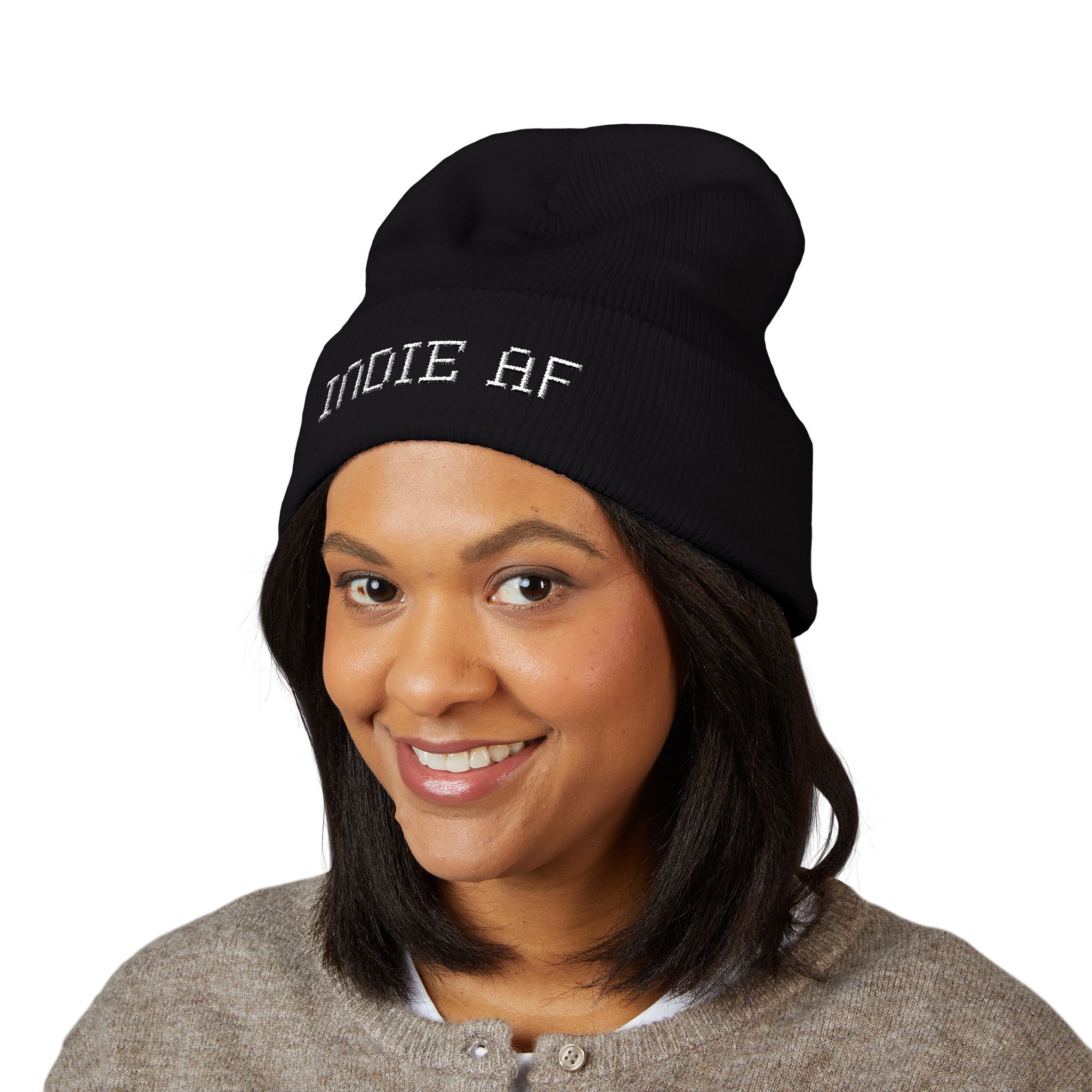 A woman smiles in a beige sweater and The Deep Dive: Indie AF 2025 Holidays by Grown cuffed beanie with light embroidery—perfect for showcasing this stylish holiday accessory against a crisp white background.
