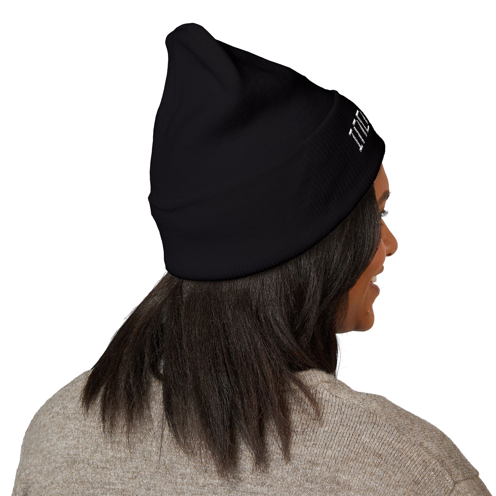 Person wears The Deep Dive: Indie AF 2025 Holidays by Grown cuffed beanie with light embroidery, paired with a light brown sweater—seen from behind with dark shoulder-length hair for a true indie vibe.