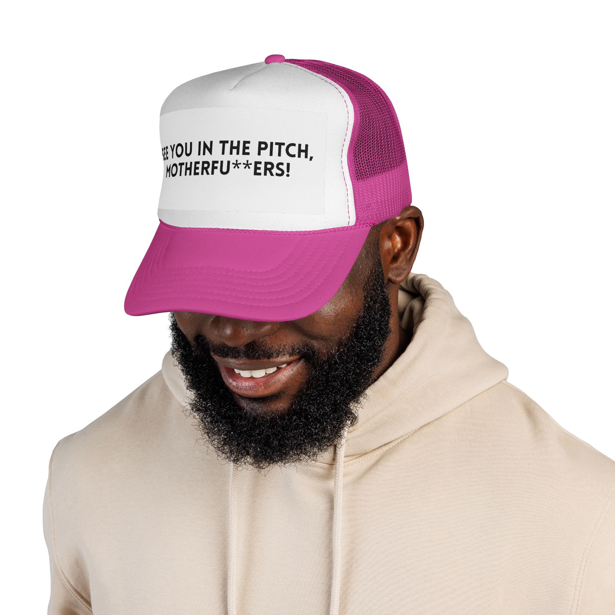 A man wears The "See You in the Pitch, Motherfu**ers!" Trucker Hat, which is pink and white with bold text on the front, along with a cream hoodie.