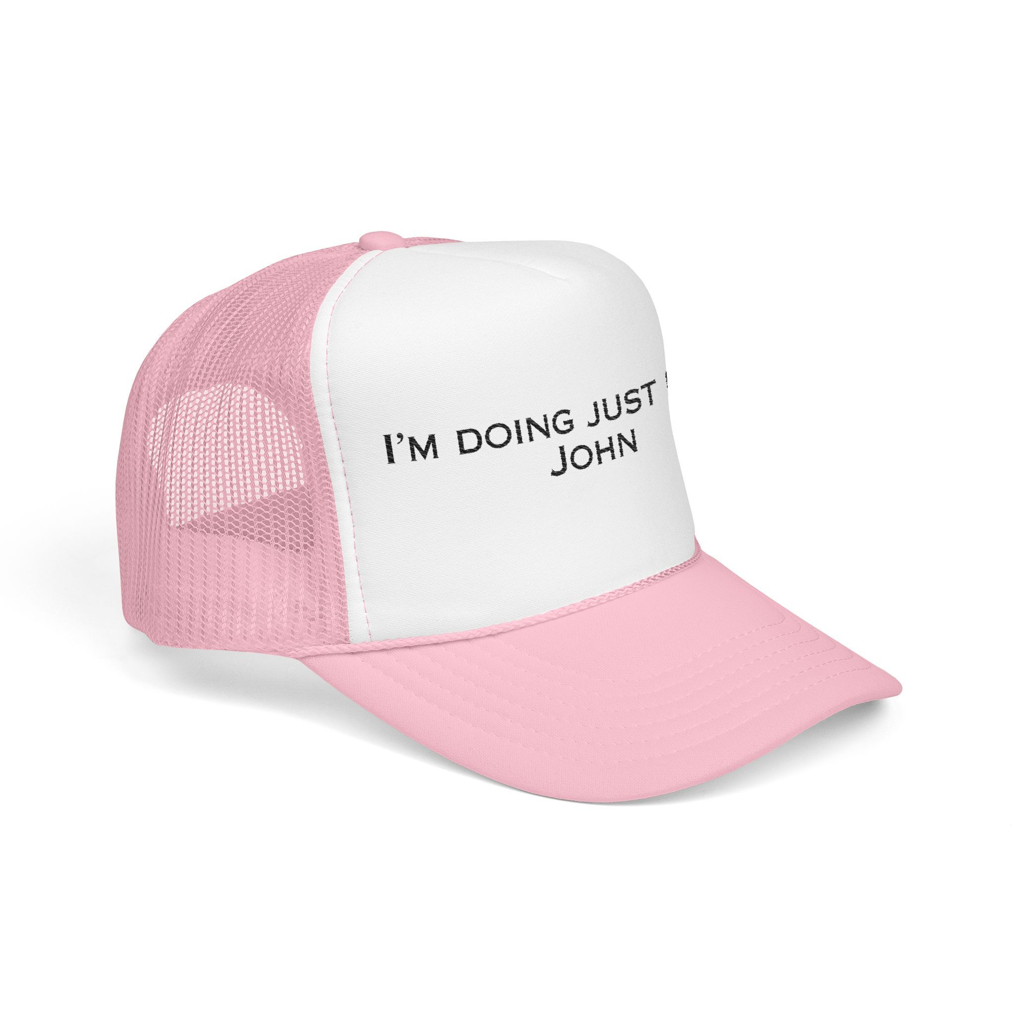 The "I'm Doing Just Fine, John" Trucker Hat (light color options) features bold black text across the front panel and comes in pink and white.