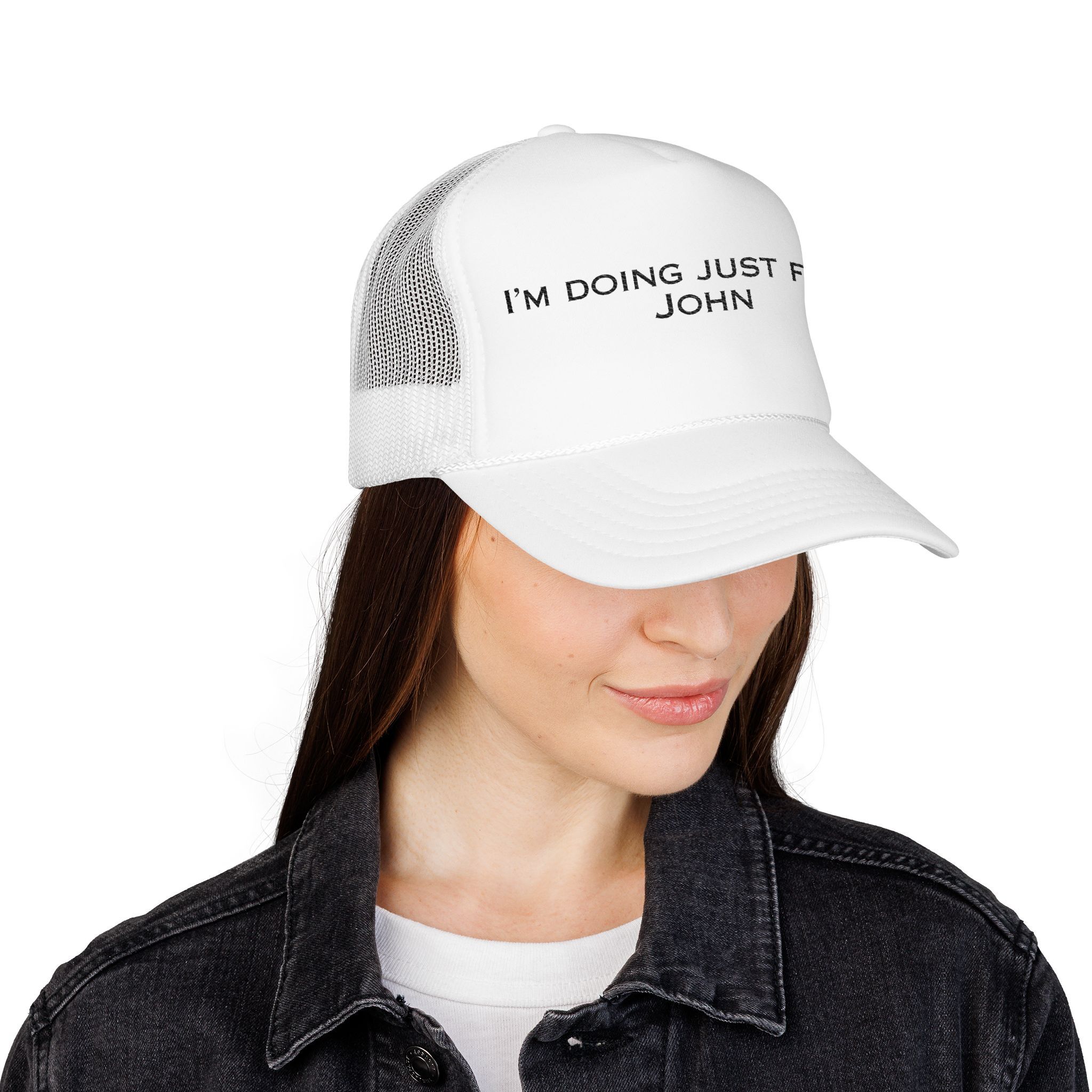 Woman wearing The "I'm Doing Just Fine, John" Trucker Hat (light color options) and a black denim jacket.
