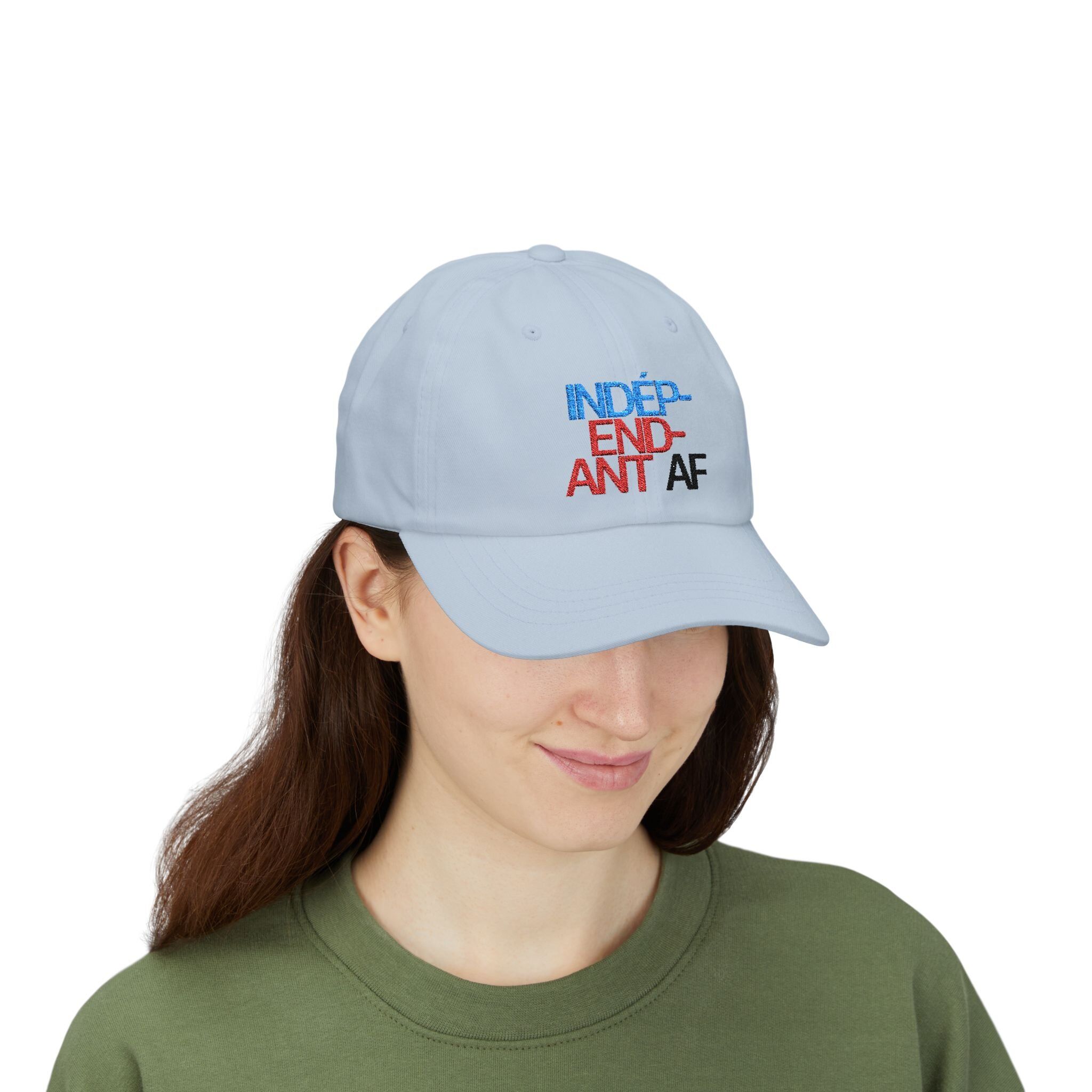A person sports The Macrons Secret Weakness Baseball Cap in light gray with INDEP-END-ANT AF embroidered in blue, red, and black—perhaps concealing a vulnerability even Macron couldn’t guess.