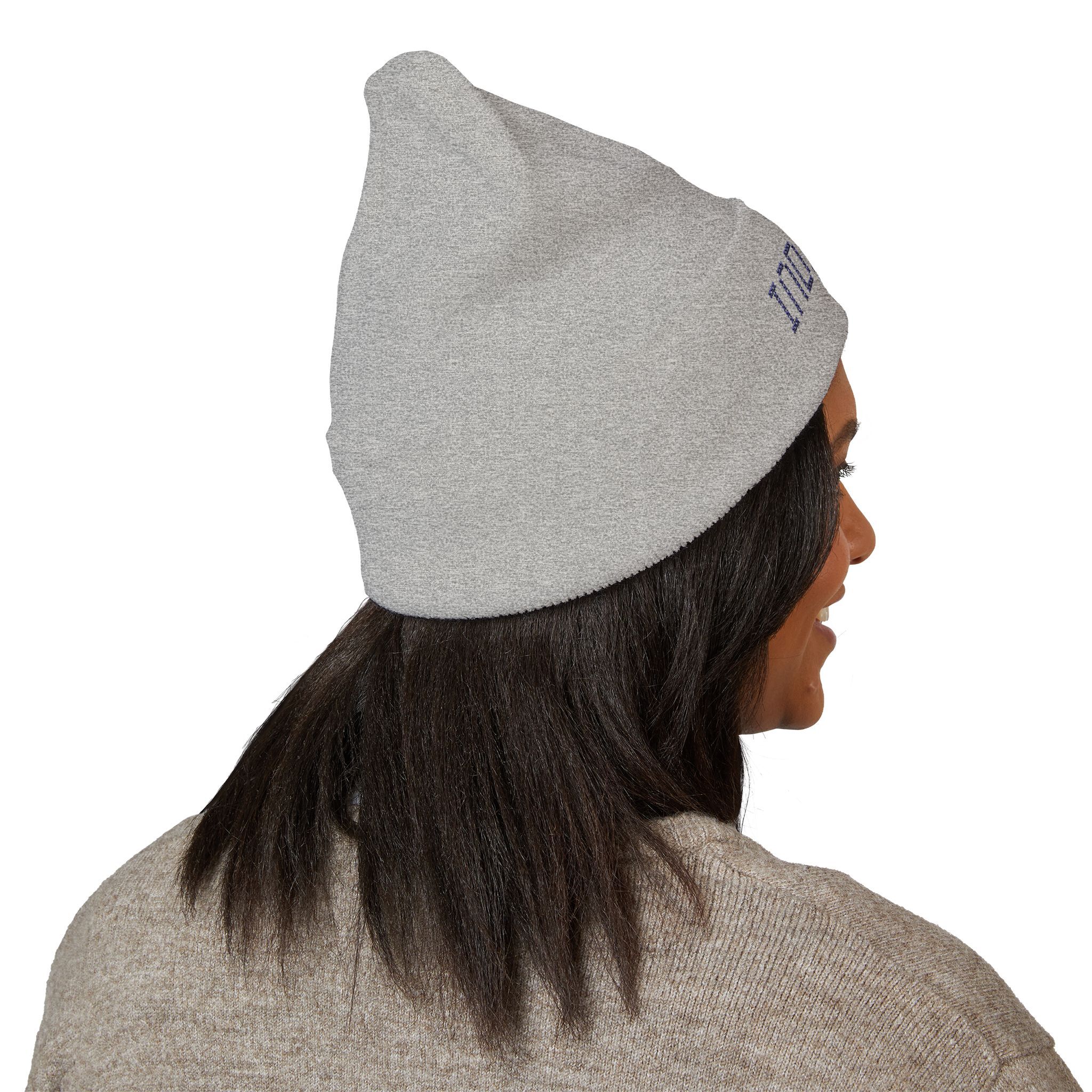 A person with straight dark hair faces away from the camera in a light gray Indie AF 2025 Holidays by Grown: Cuffed Beanie with dark embroidery and a beige sweater, creating an effortlessly indie vibe against a white background.